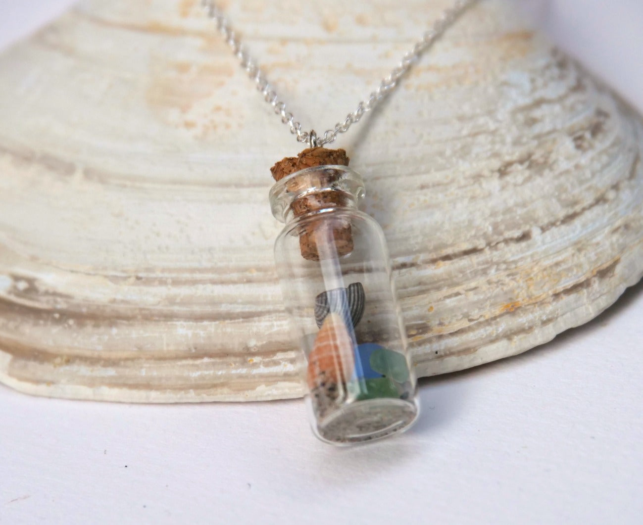 Glass bottle pendant necklace filled with colourful sea shells and beach sand. Handmade in Canada by Bridget Turner.