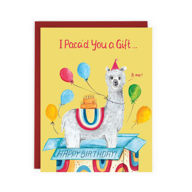 Hand drawn Made in Canada birthday card with an alpaca inside a present box, wearing a party hat, balloons and a cake on its back. Caption reads: I Paca'd You a Gift...It me!