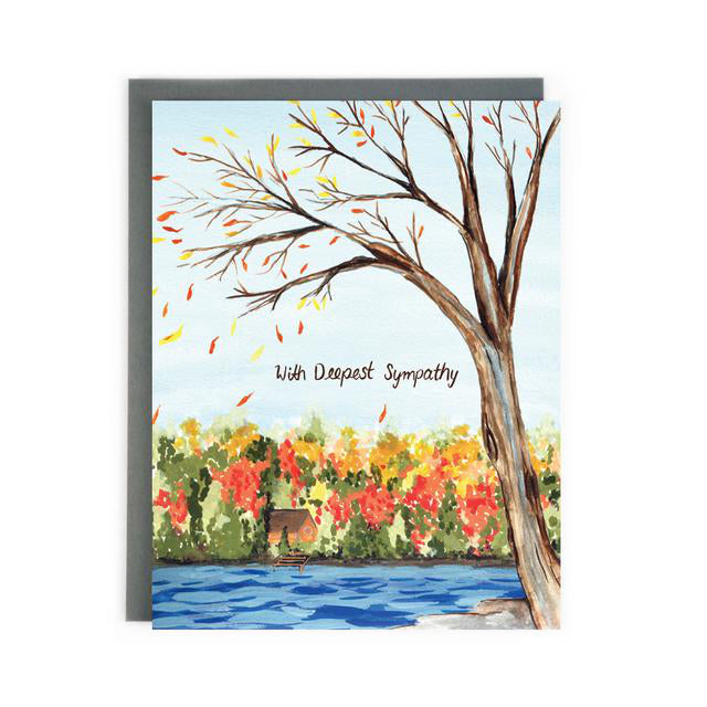 Made in Canada sympathy card with hand painted autumn scene of a cabin by a blue lake, with red and yellow leaves on the trees. Caption reads: With Deepest Sympathy