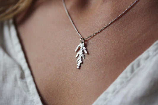 Made in Canada Justine Brooks tiny silver cedar leaf charm necklace.