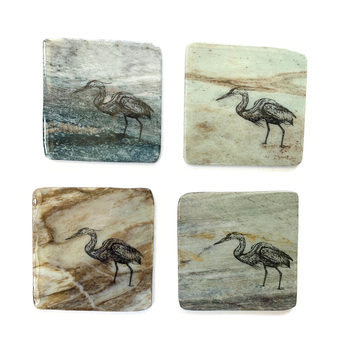 Various granite coasters with blue heron design made in Canada.