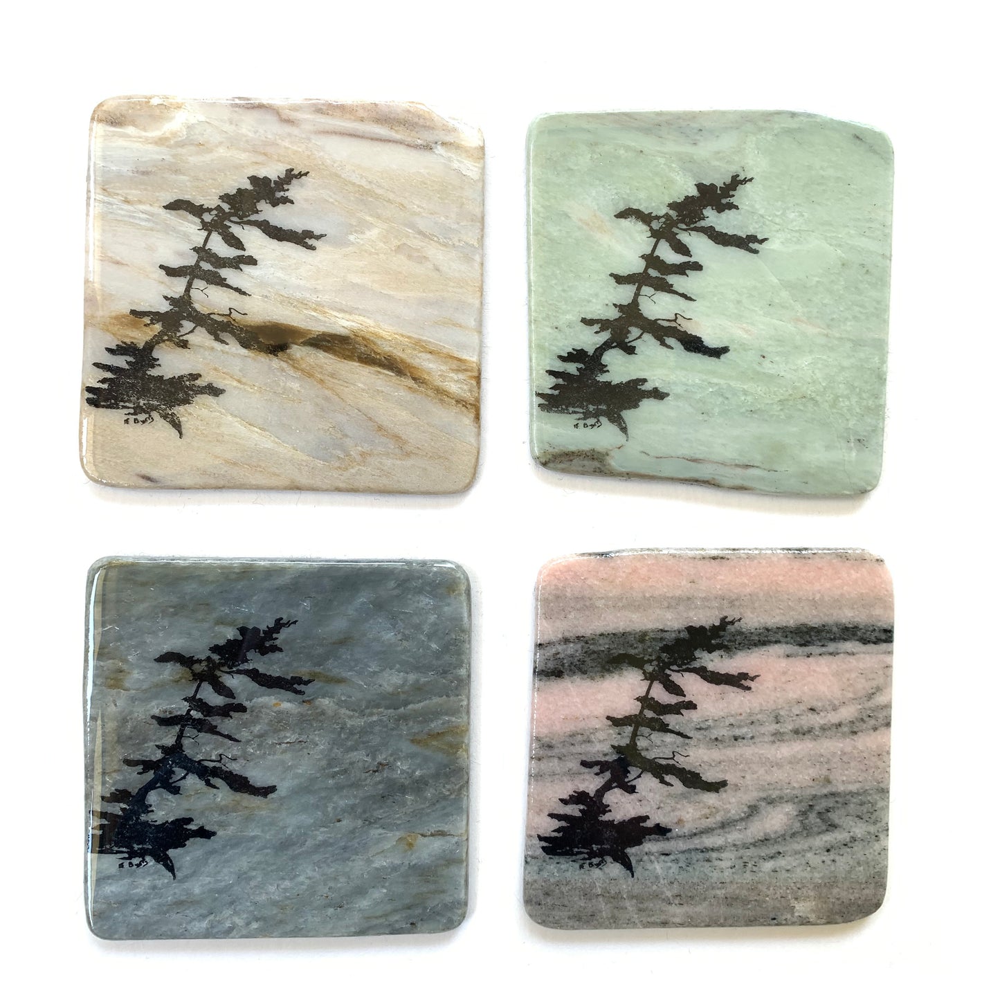 Various granite coasters with windswept pine design made in Canada.